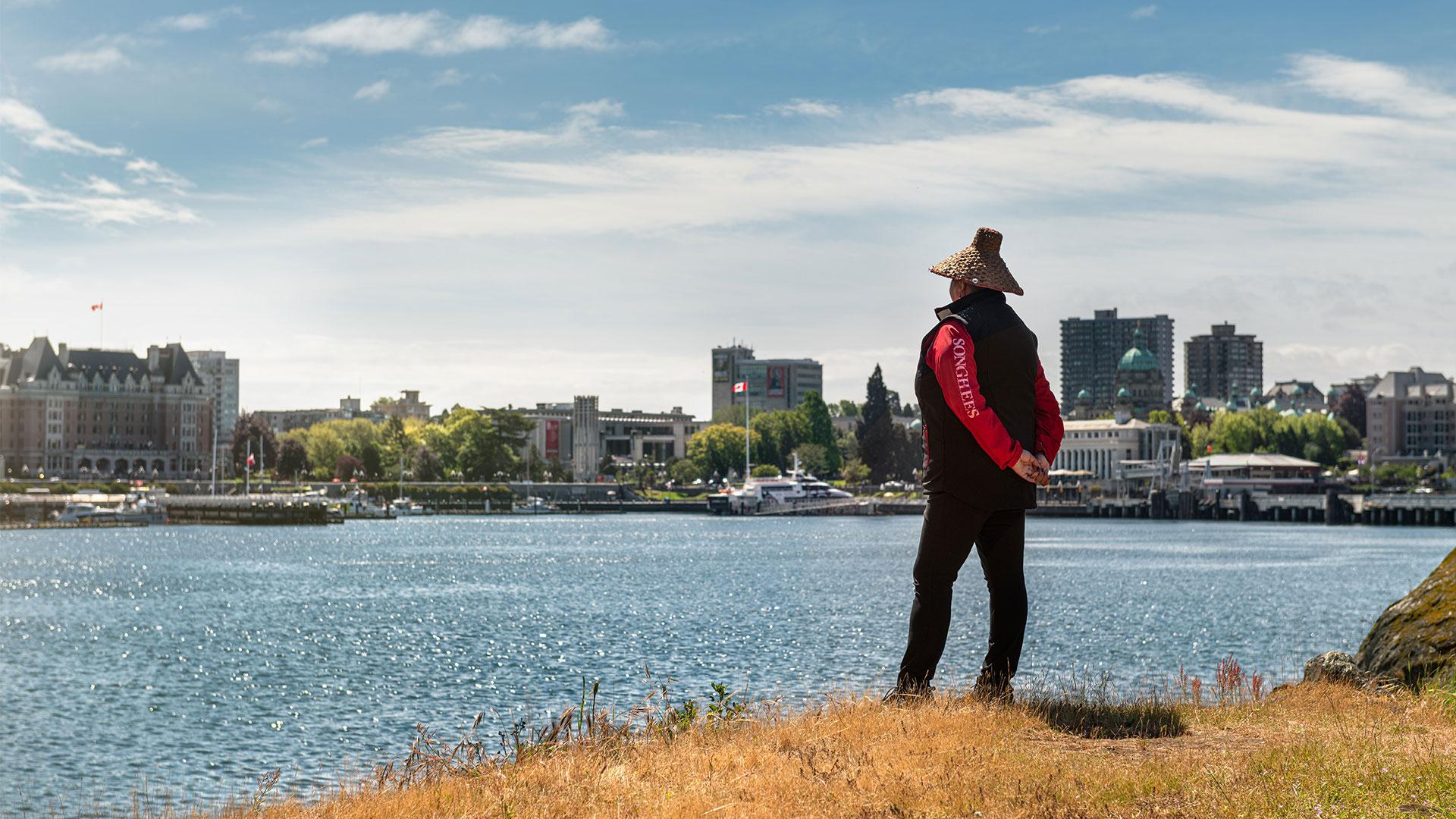 A person looks out over the water in Victoria, BC