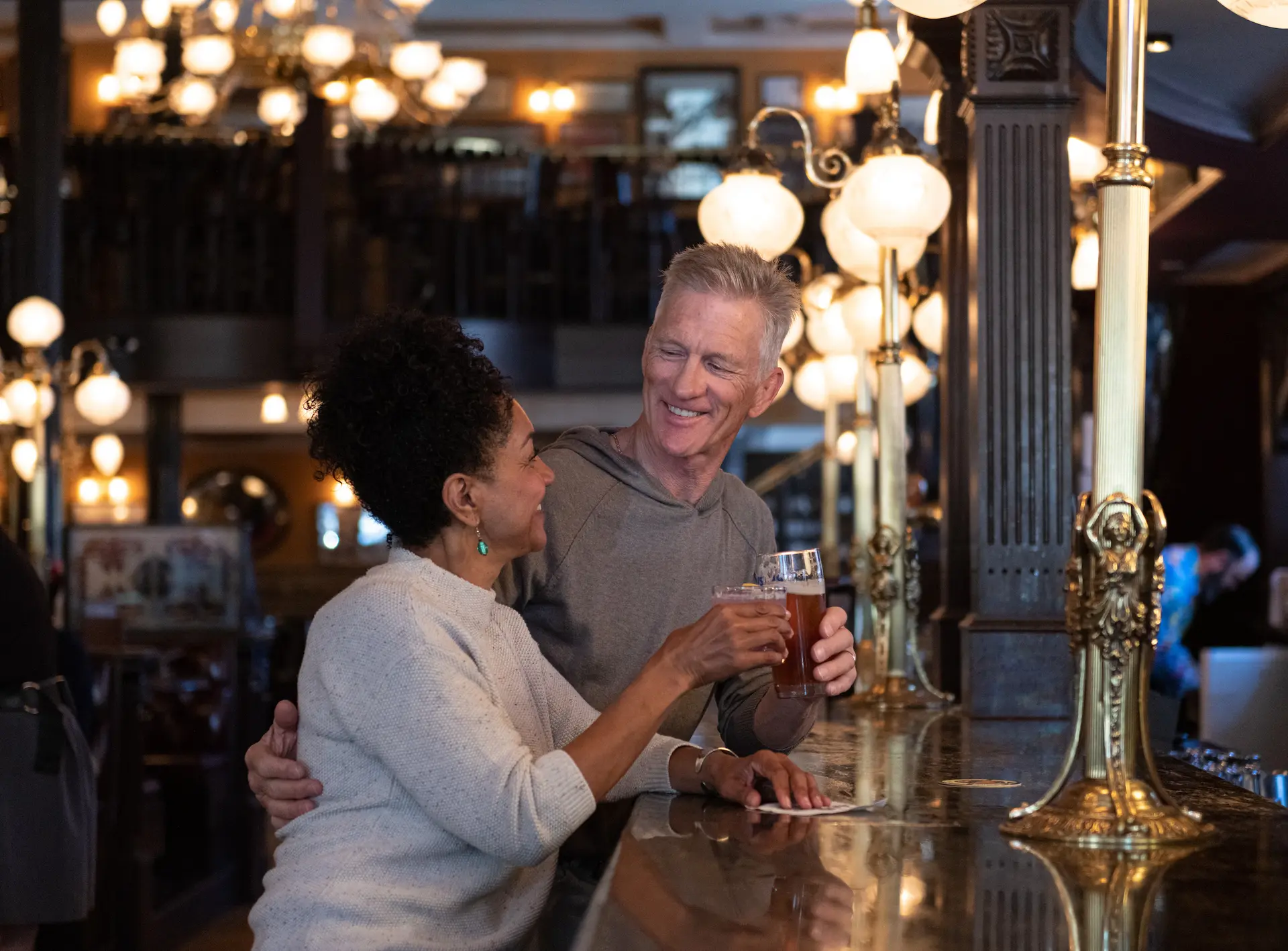A couple enjoying a drink at the bar at the Bard & Banker in Victoria, BC