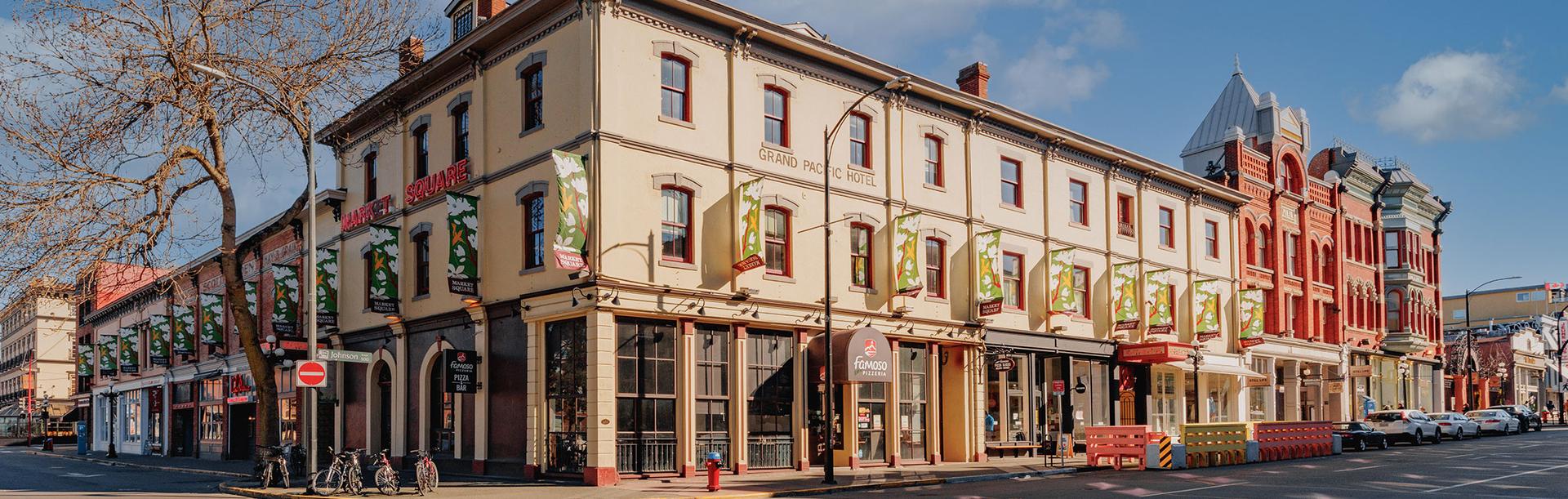 Historic Market Square in downtown Victoria, BC with heritage buildings, shops, and a sunny street corner
