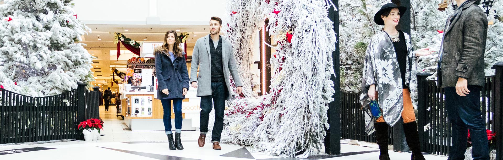 A couple walks through a Christmas display at the Bay Centre Shopping Centre in Victoria, BC