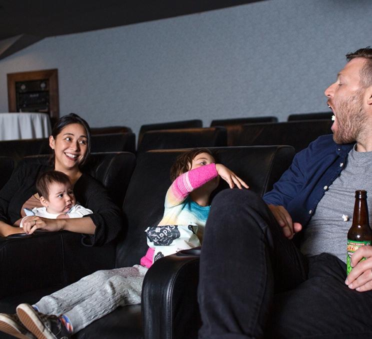 A family watches a movie in the private theatre at Parkside Hotel & Spa in Victoria, BC