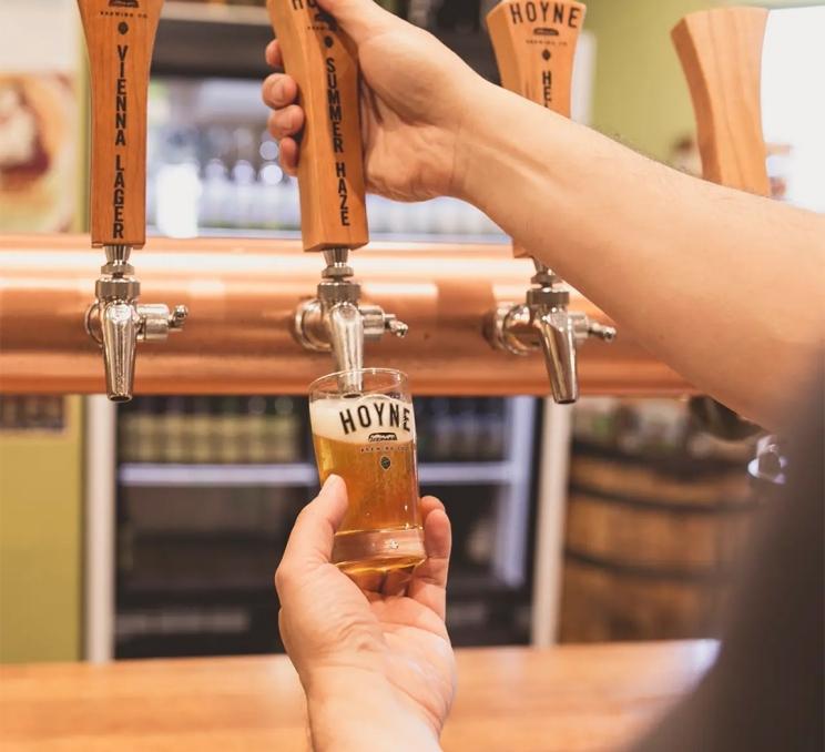 Someone pours a taster of Hoyne Beer at a tasting room in Victoria, BC