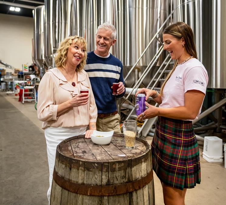 A couple receives a brewery tour from a guide at Macaloney's Island Distillery in Victoria, BC