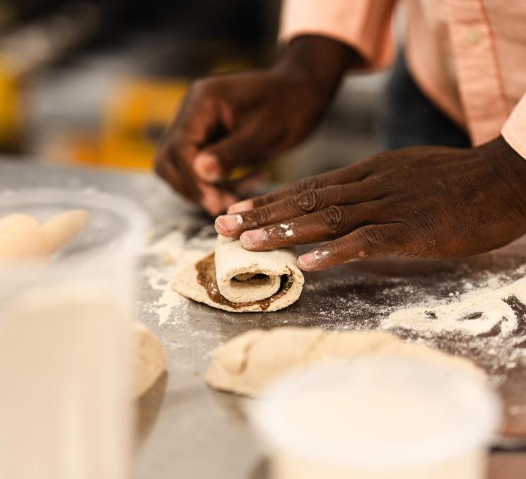 A person rolls cinamon sugar into a pastry during a workshop at the Art of Slow Food in Victoria, BC