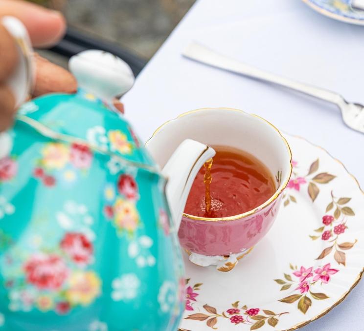 A person pours a cup of tea from a teapot at the Teahouse at Abkhazi Garden in Victoria, BC