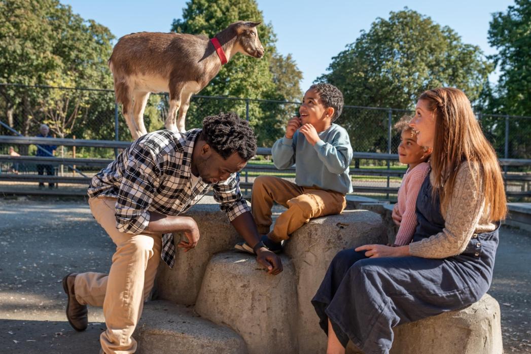 a smiling family enjoying the petting zoo at Beacon Hill Park