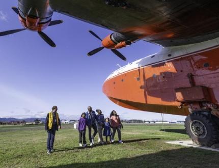 A family inspects a water bomber aircraft at the BC Aviation Museum during a guided tour in Victoria, BC