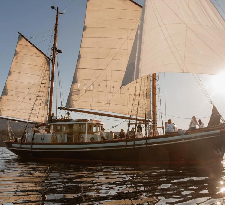 A sailboat sails across the Salish Sea off the coast of Victoria, BC