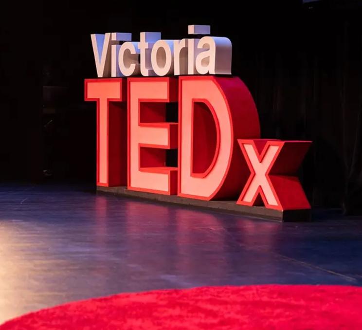 A white and red TEDxVictoria sign displayed on stage during TEDxVictoria in Victoria, BC