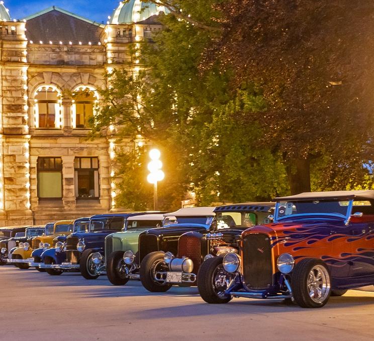 A row of Deuce Coups outside the BC Parliament Buildings during Northwest Deuce Day at sunset in Victoria, BC