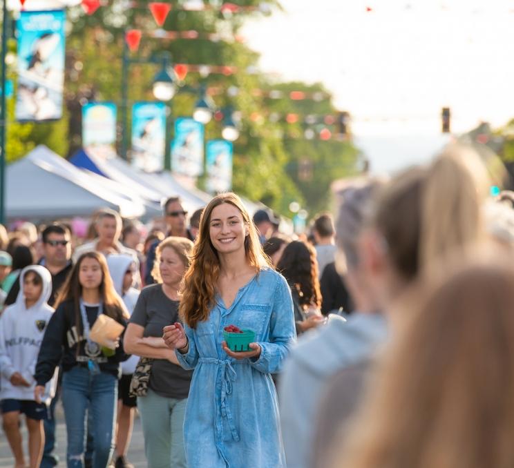 A woman walks through a crowd at the Sidney Street Market in Victoria, BC