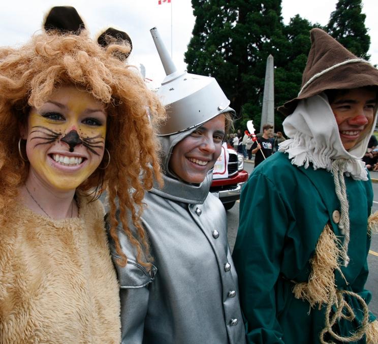 Three people dressed as Cowardly Lion, the Tin Man, and Scarecrow parade as the friends of Dorothy during the parade at Victoria Pride Week in Victoria, BC