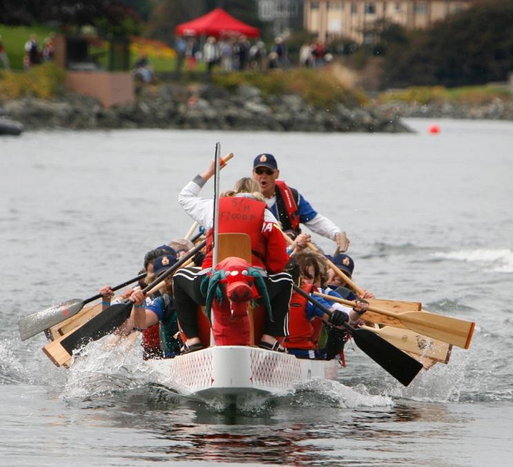 A team of rowers row a boat across the Inner Harbour at the Canada Dry Victoria Dragon Boat Festival in Victoria, BC