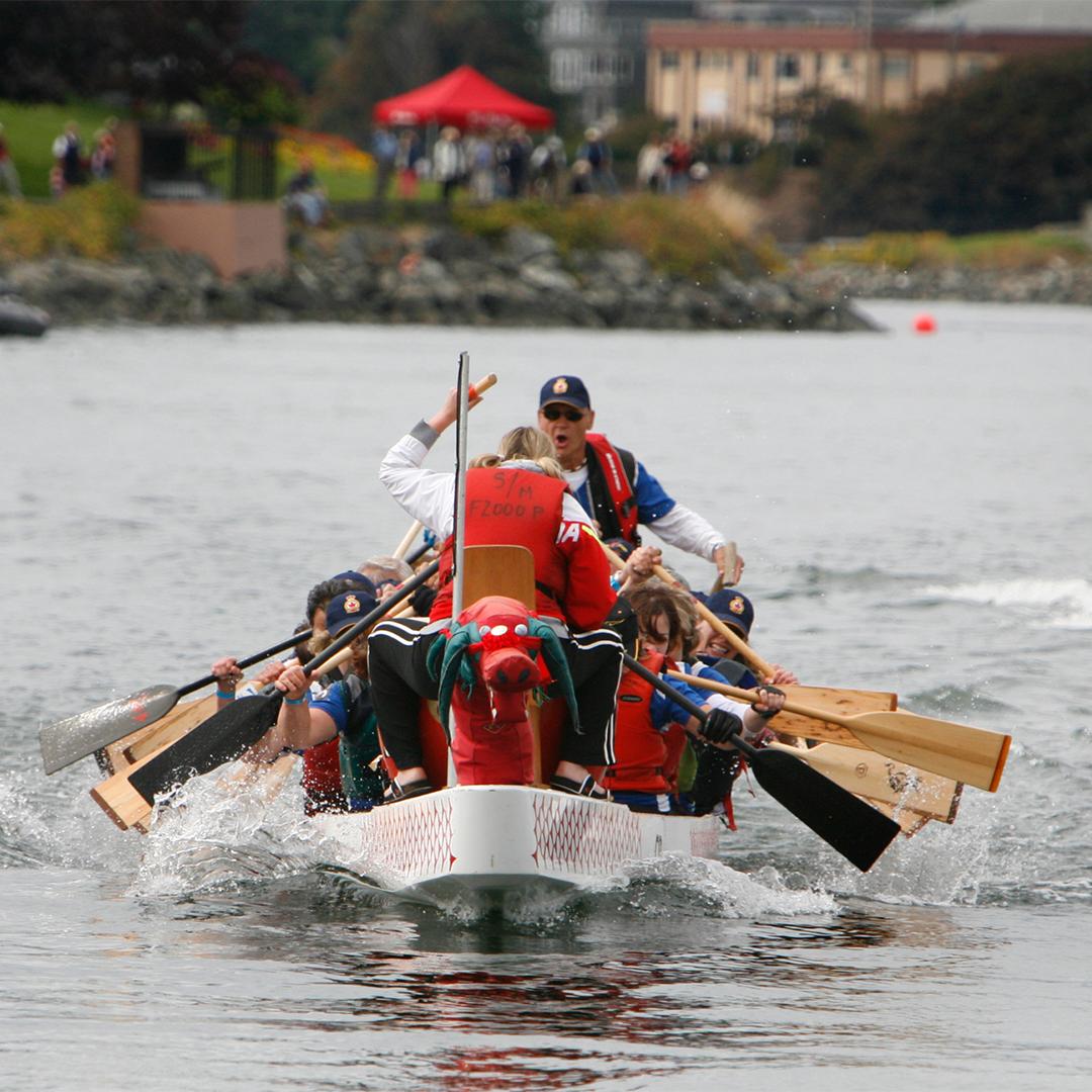A team of rowers row a boat across the Inner Harbour at the Canada Dry Victoria Dragon Boat Festival in Victoria, BC