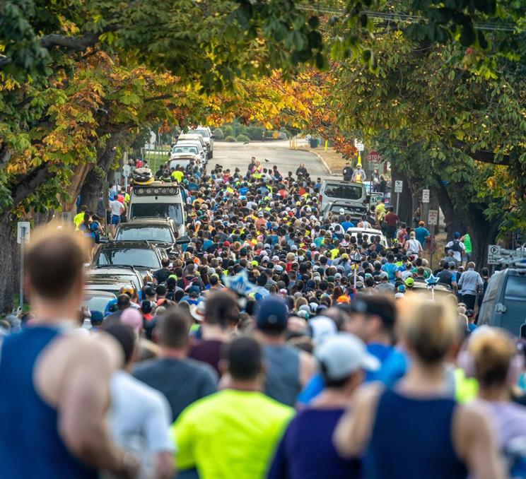 Runners of the Royal Victoria Marathon run down a treed street in Victoria, BC