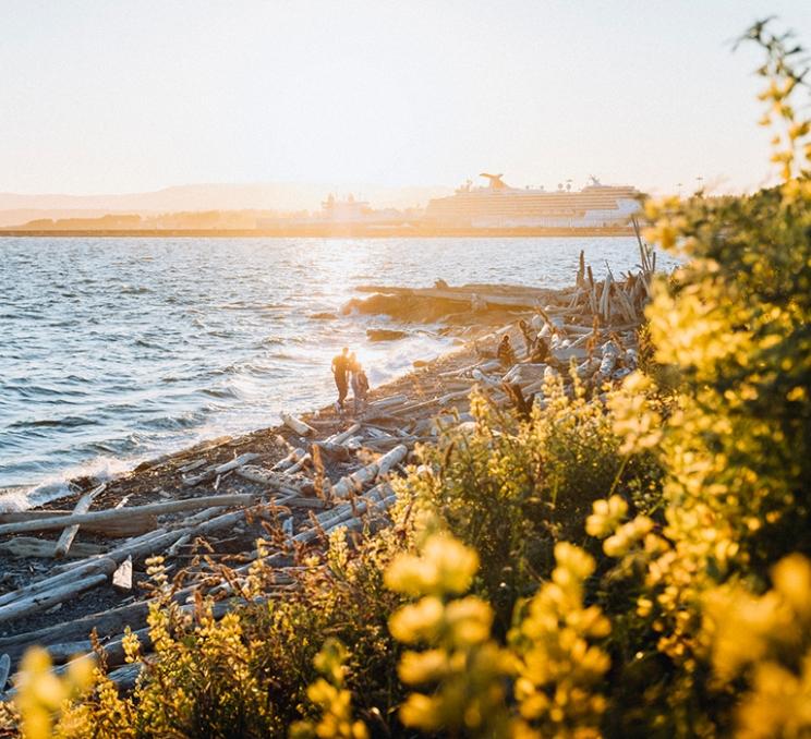 A couple walks along the beach in Victoria, BC