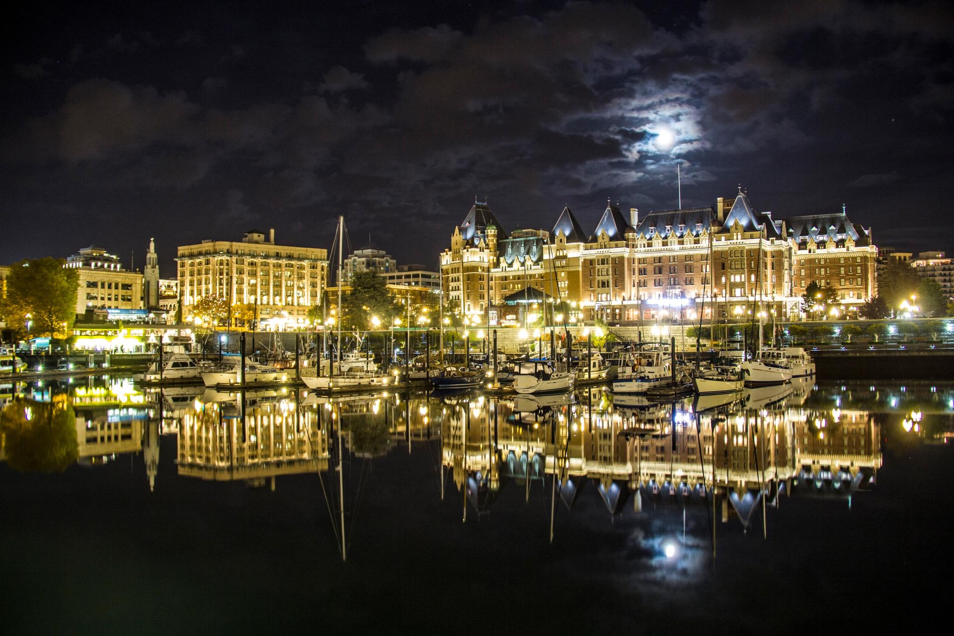 A full moon hangs over Victoria, BC's Inner Harbour