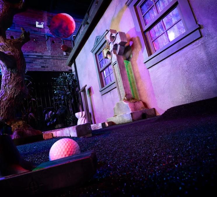 Someone about to putt at Haunted Manor Victoria's minigolf course.