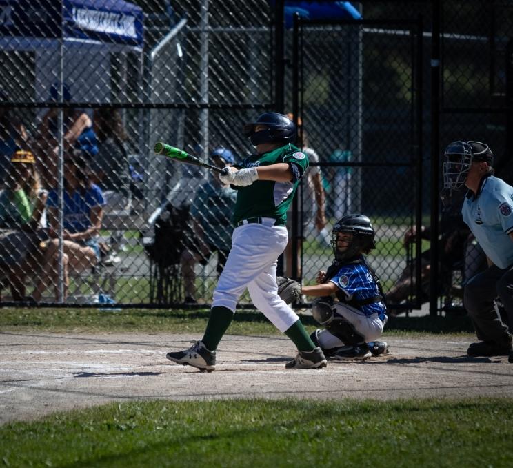 A little league baseball player swings while at bat at Layritz Little League in Victoria, BC