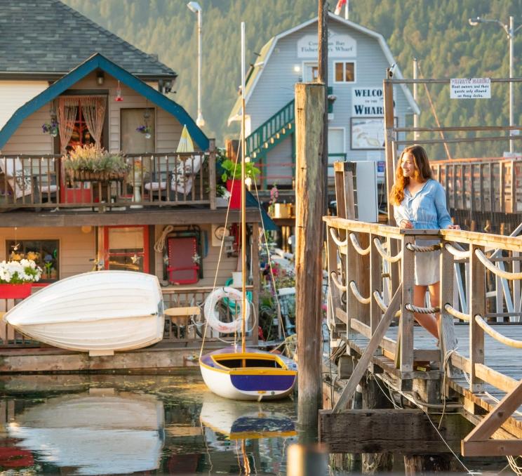 A woman looks out over the marina in Cowichan Bay, just outside of Greater Victoria, BC