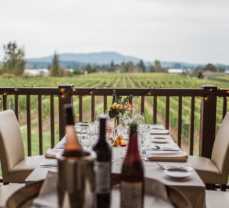 A dining table on a patio is set-up for a wedding overlooking the vineyard of Church & State Winery in Victoria, BC