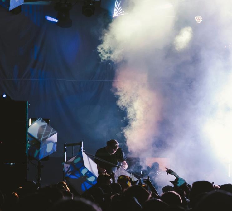 A performer plays a DJ set at the Rifflandia Music Festival while a smoke machine billows out smoke in Victoria, BC