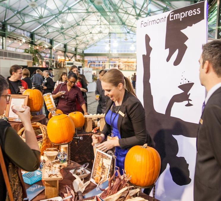 A woman serves cocktails from the Fairmont Empress booth at Art of the Cocktail in Victoria, BC