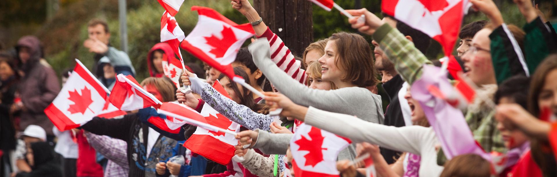 A group of flag waiving Canadians celebrate Canada Day in Victoria, BC