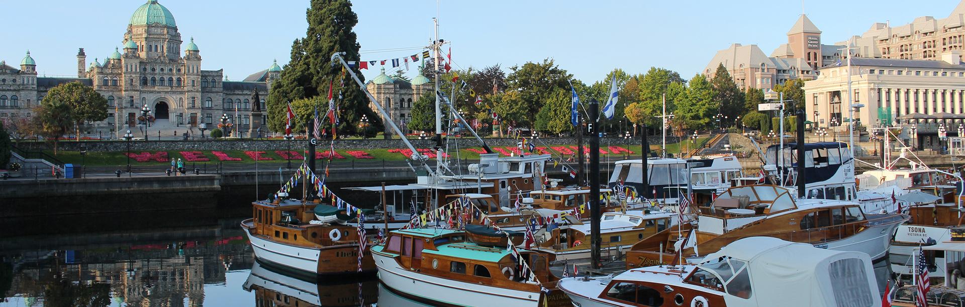 Classic boats with a wooden trim fill the Inner Harbour across from the BC Parliament Buildings in Victoria, BC