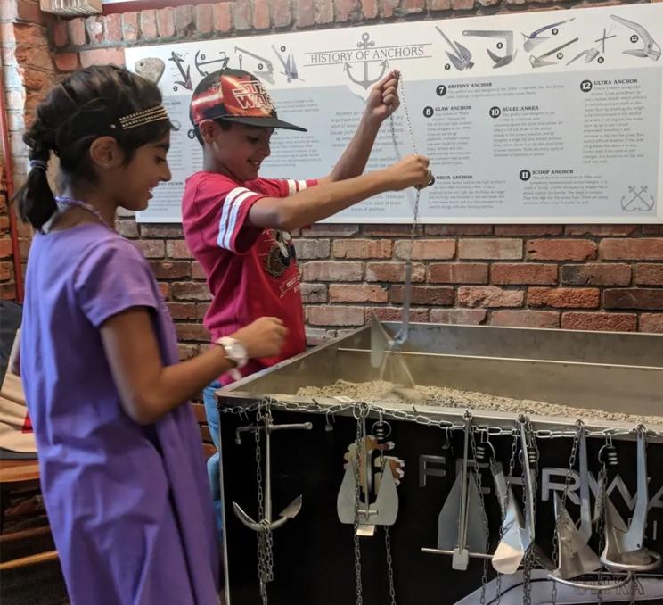 Two children play with an anchor exhibit at the Maritime Museum of BC in Victoria, BC