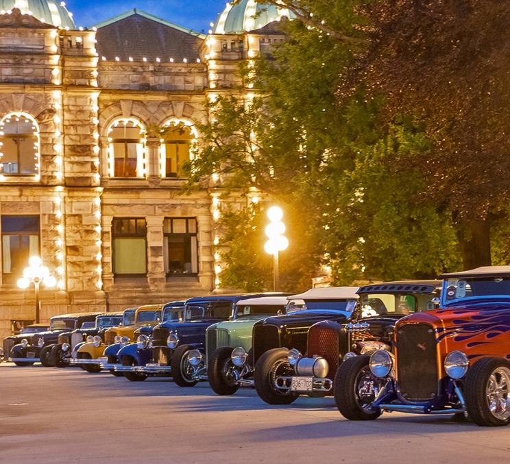 A row of Deuce Coups parked in front of the BC Parliament Buildings during Northwest Deuce Days in Victoria, BC