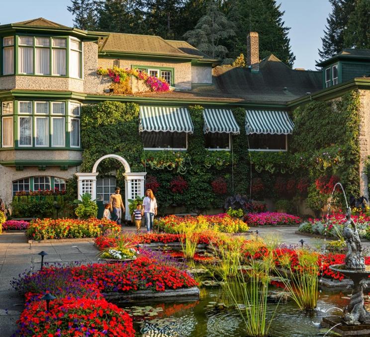 A young family explores the Italian Garden at The Butchart Gardens in Victoria, BC