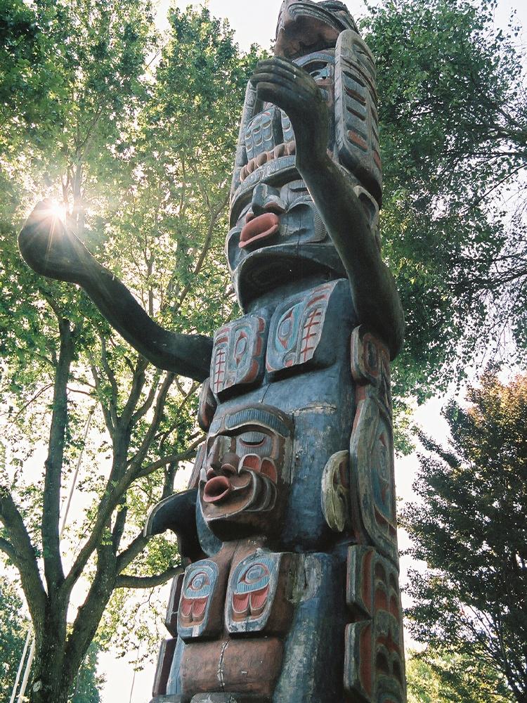 A totem pole in a treed area in Greater Victoria, BC