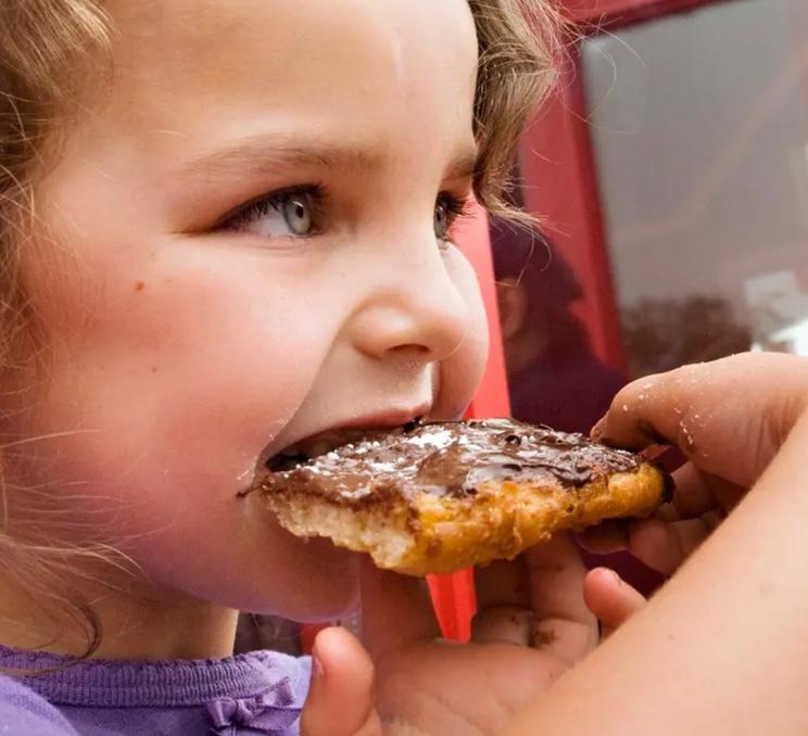 A young girl eats a BeaverTail in Victoria, BC