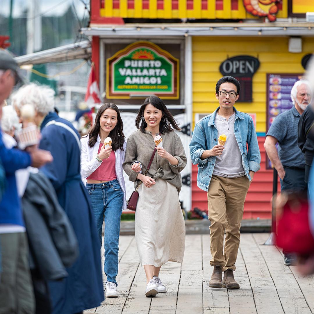 A young family enjoys ice cream while out for a walk along Fisherman's Wharf in Victoria, BC