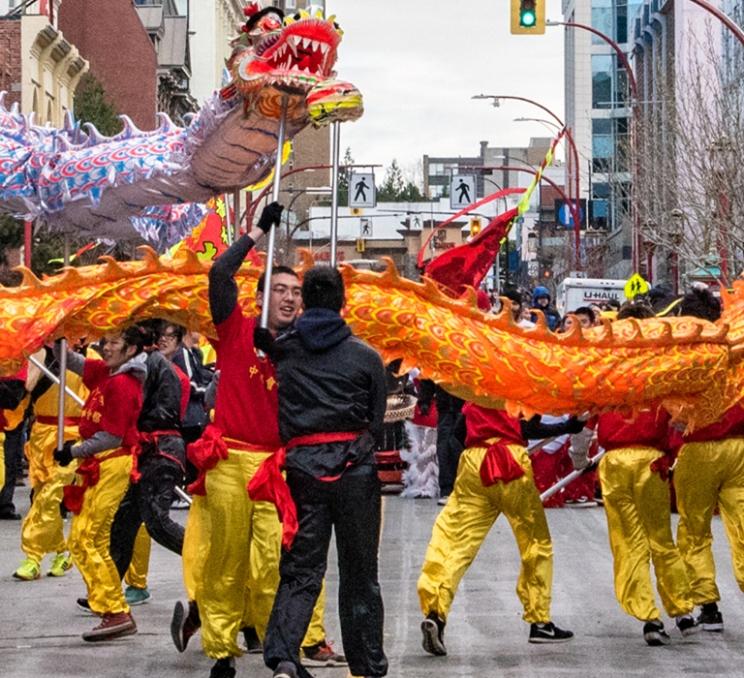 A yellow and red dragon parades through Chinatown in Victoria, BC