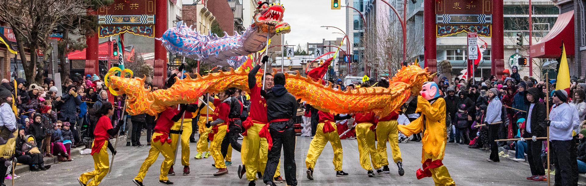 A yellow and red dragon parades through Chinatown in Victoria, BC