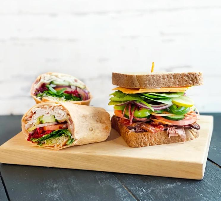 A sandwich and a wrap on a cutting board at Red Barn Market in Victoria, BC