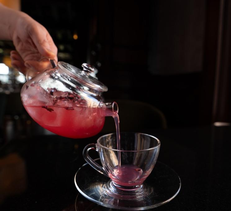 A pink tea based beverage is poured at sunset sips at the Fairmont Empress in Victoria, BC