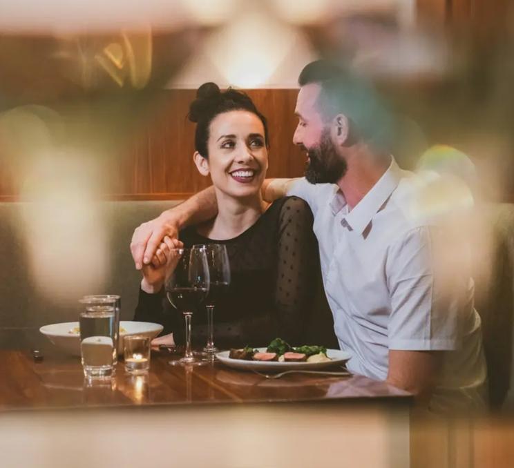A couple chats while eating dinner at The Palms in Victoria, BC
