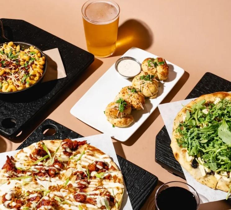 A spread of pizza appetizers and beer at Virtuous Pie in Victoria, BC