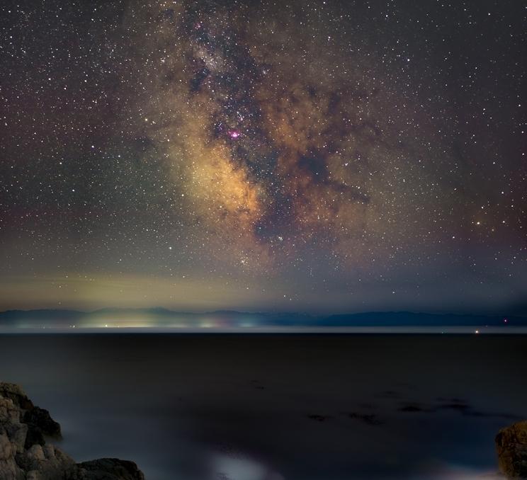 The milky way appears above the Salish Sea as seen from Saxe Point Park in Victoria, BC
