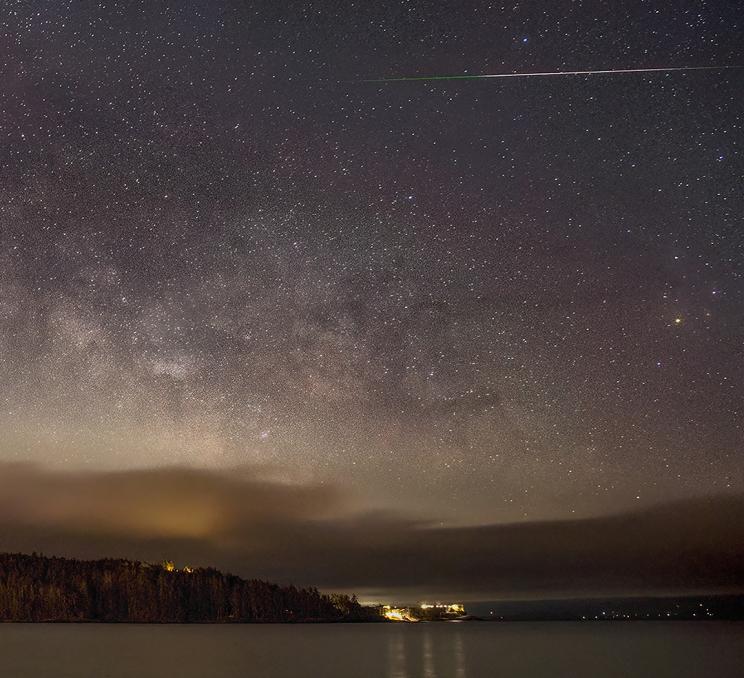 A meteor streaks through the sky above Whiffin Spit in Sooke, BC