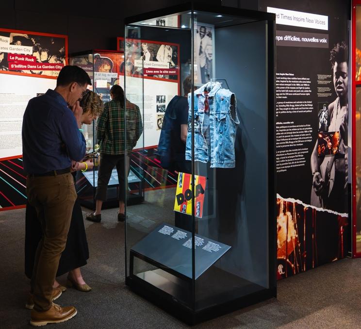 A couple examines a jacket on display at the Royal BC Museum's Beyond the Beat exhibit in Victoria, BC