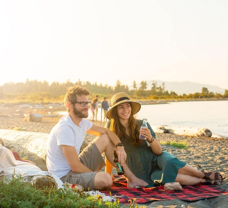 A couple enjoys a summer picnic on a beach in Greater Victoria, BC