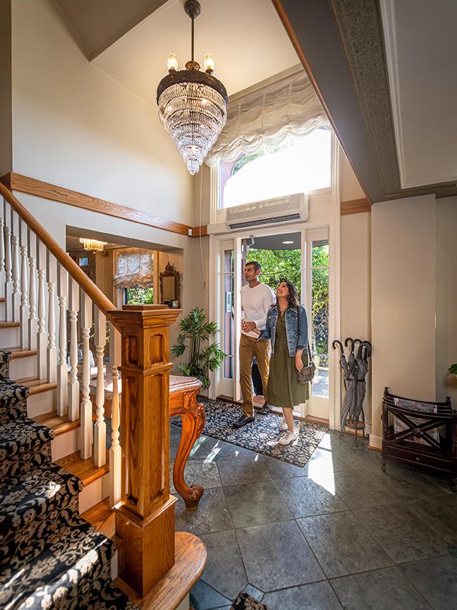 A couple walks through the doorway of Abigail's Hotel as a chandelier hangs overhead in Victoria, BC