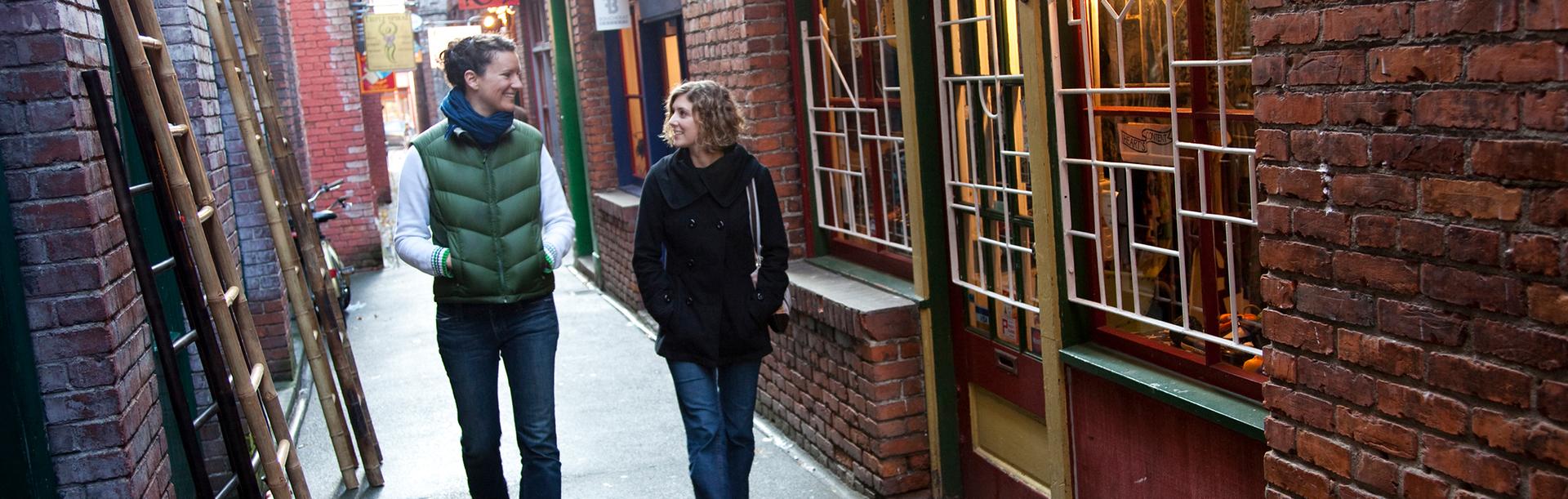 Two people walk through Fan Tan Alley in Victoria, BC