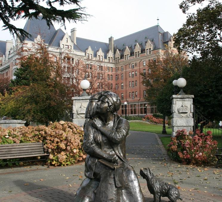 A statue of Emily Carr and her pet monkey in front of the Fairmont Empress in Victoria, BC