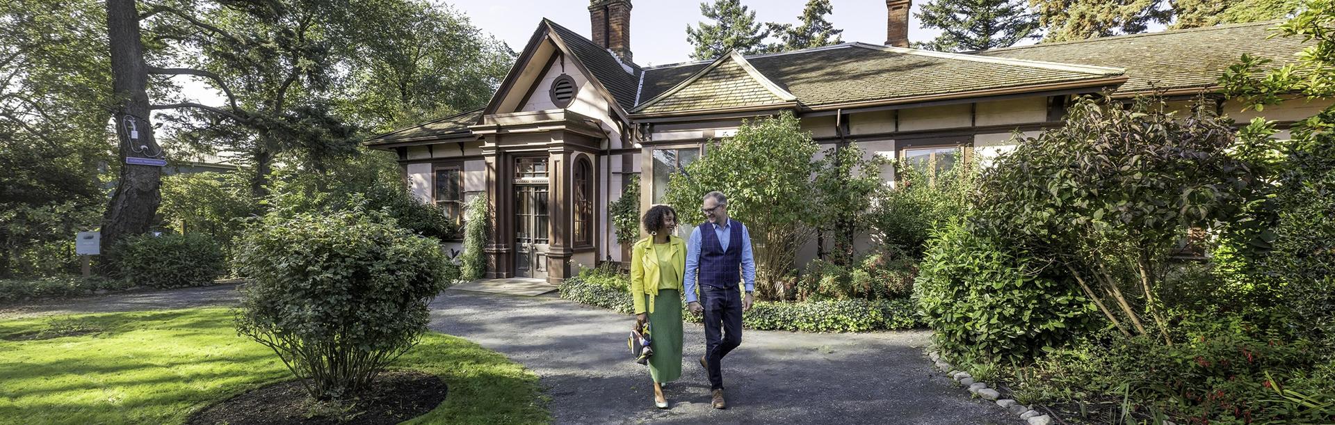 A couple walks hand-in-hand through the garden of Point Ellice House in Victoria, BC