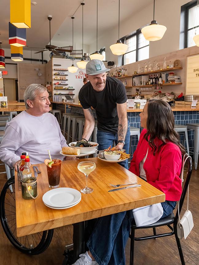 A couple is served a seafood dinner at Shuck Taylor's in Victoria, BC